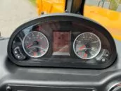 Close-up of a vehicle dashboard with gauges showing RPMs, temperature, fuel level, and digital screen displaying various readings.