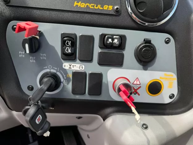 Control panel with various switches and keys, labeled Hercules, includes ignition key, tool selection, and warning indicators.