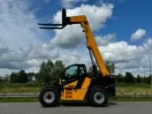 Yellow Dieci telescopic forklift with extended boom outdoors under a cloudy blue sky.