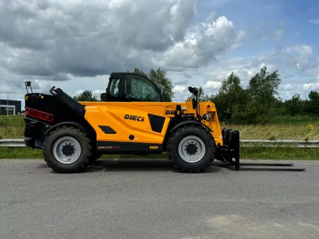 Yellow Dieci Hercules 130.10 telehandler on a paved road with green trees and cloudy sky in the background.